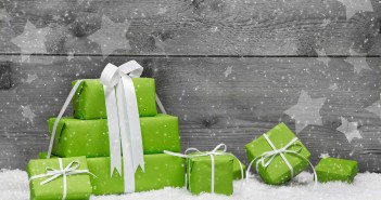 Gifts Any Writer Will Love Green Christmas presents with snow on grey wooden background for