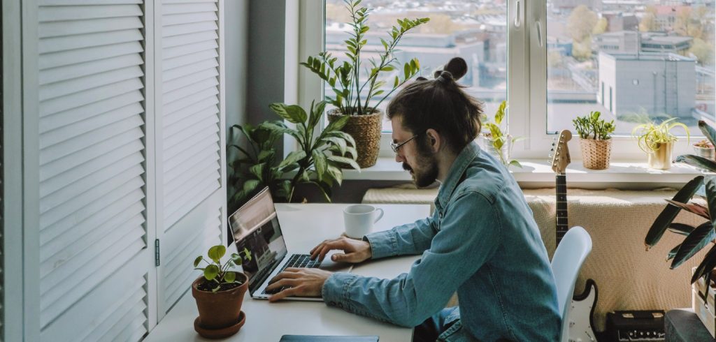 man practising writing methods on laptop at home