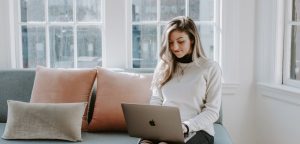 woman writing clearly and concisely on laptop at home