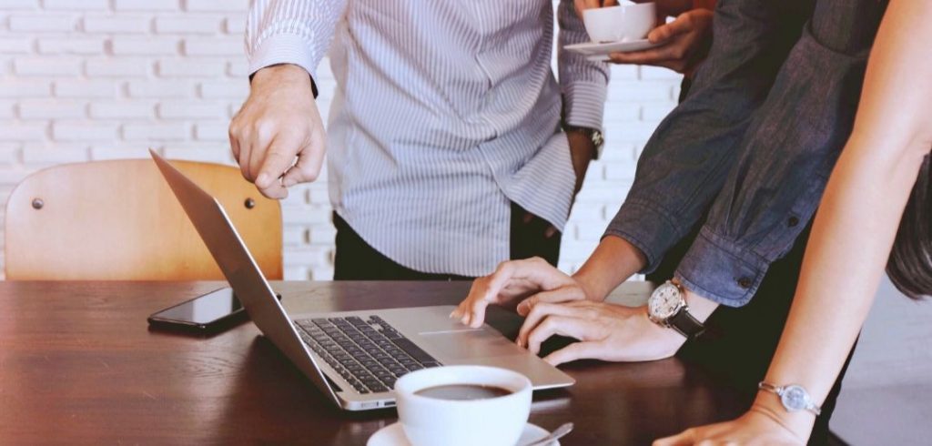 group of people around a laptop building their online writer's profiles