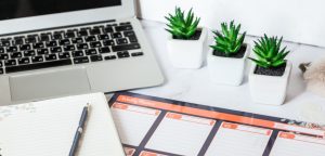 laptop with day planner on desk