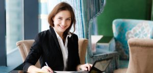 woman at a table working on a white paper