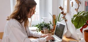 woman writing for the web on laptop at home