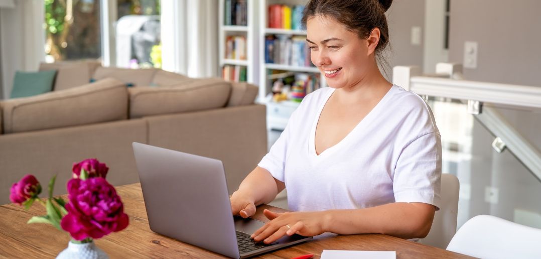 woman at kitchen table on laptop