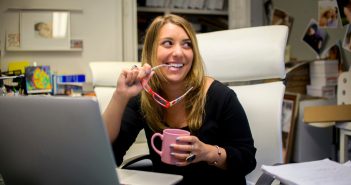 How to Find a Profitable Niche in 5 Easy Steps woman by computer smiling finding niche