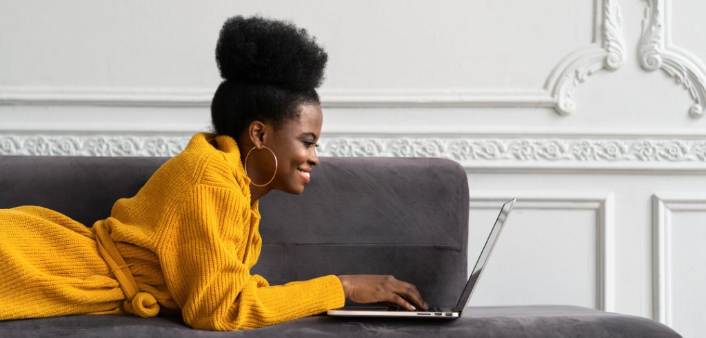 woman working on computer on couch
