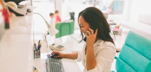 woman on computer and phone making an unschedule