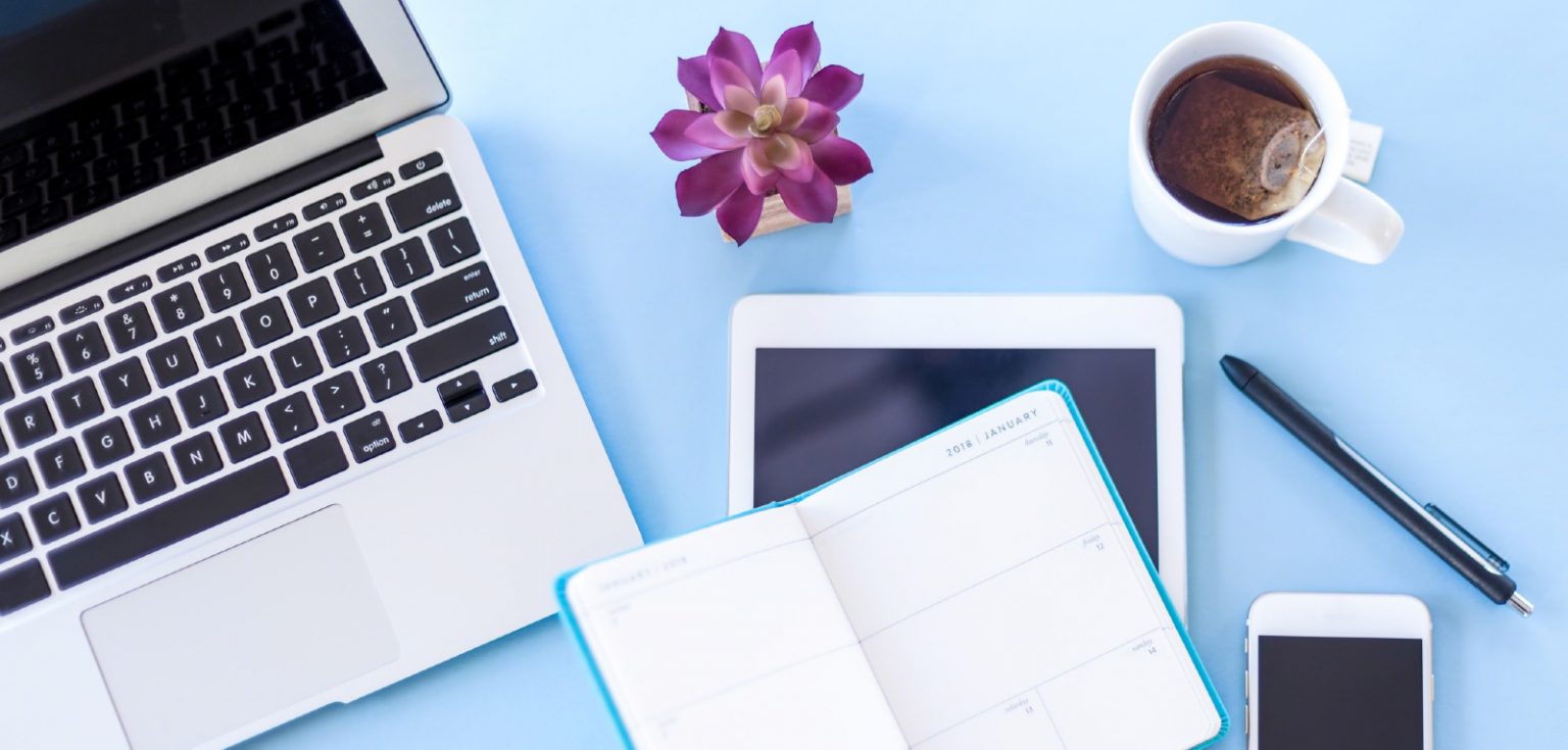 laptop on desk with day planner