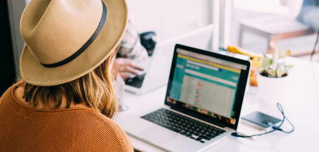 woman opening email on laptop in cafe