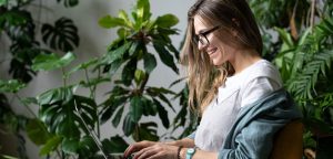 writer working on being more creative on computer with plants in background